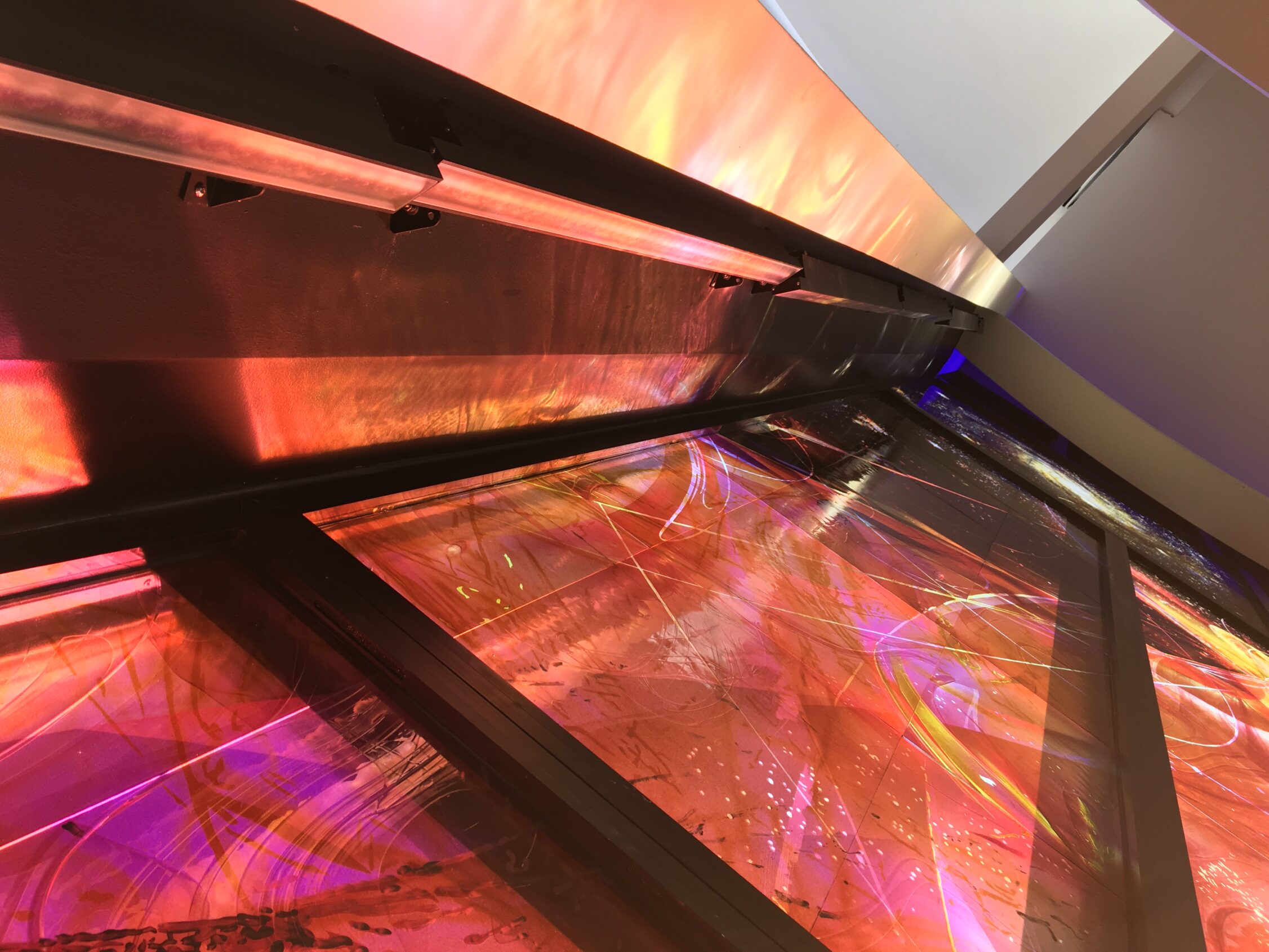 Contemporary stained glass integrated into ceiling structure, architectural glass shaping light within church interior