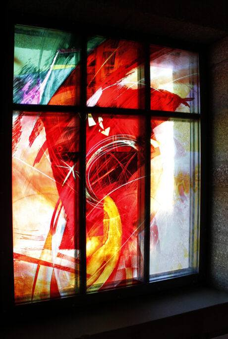 Contemporary stained glass window with dramatic color and layered imagery, liturgical commission expressing spiritual narrative