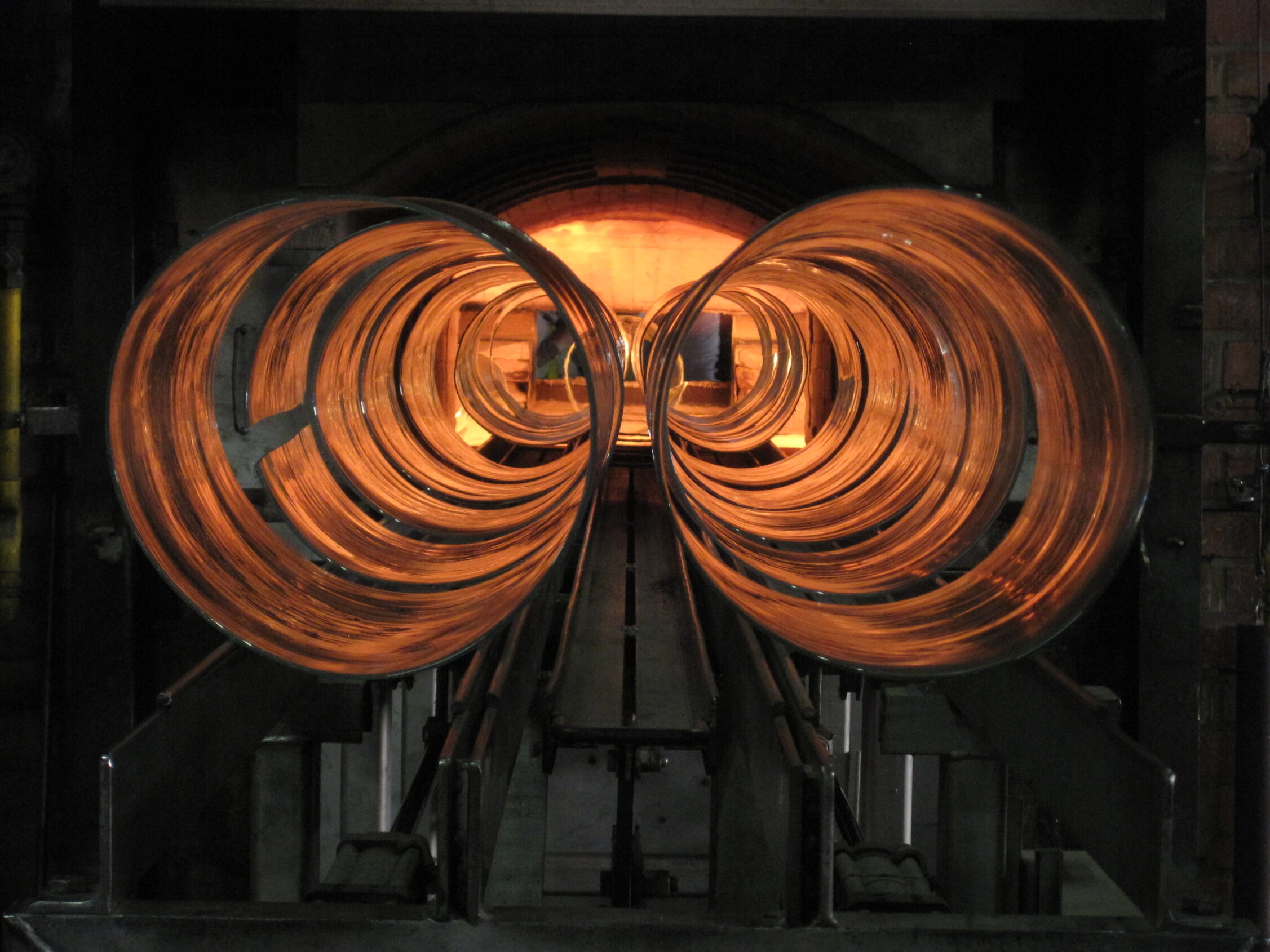 Sliced glass cylinders at Lambert entering furnace to be flattened into sheets
