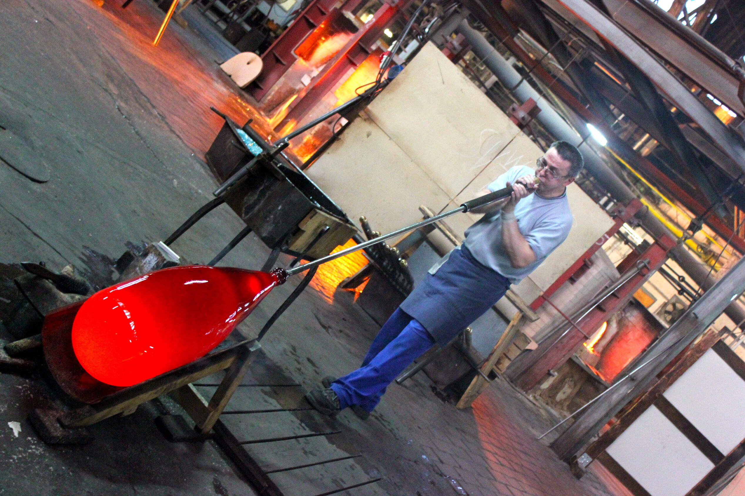 Glassblower blowing a red balloon at Lamberts Waldsassen Glassworks