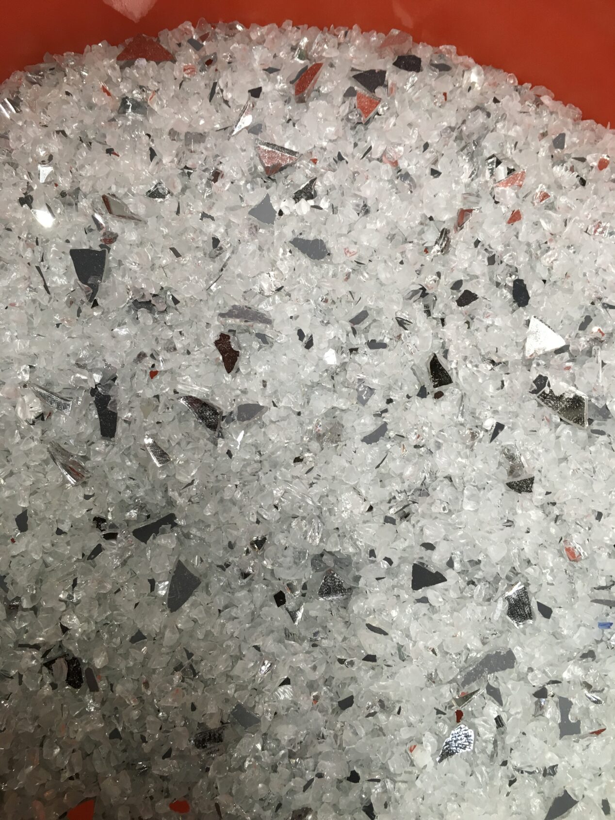 Close-up detail of an aggregate mix for epoxy terrazzo containing recycled glass and mirror in various sizes