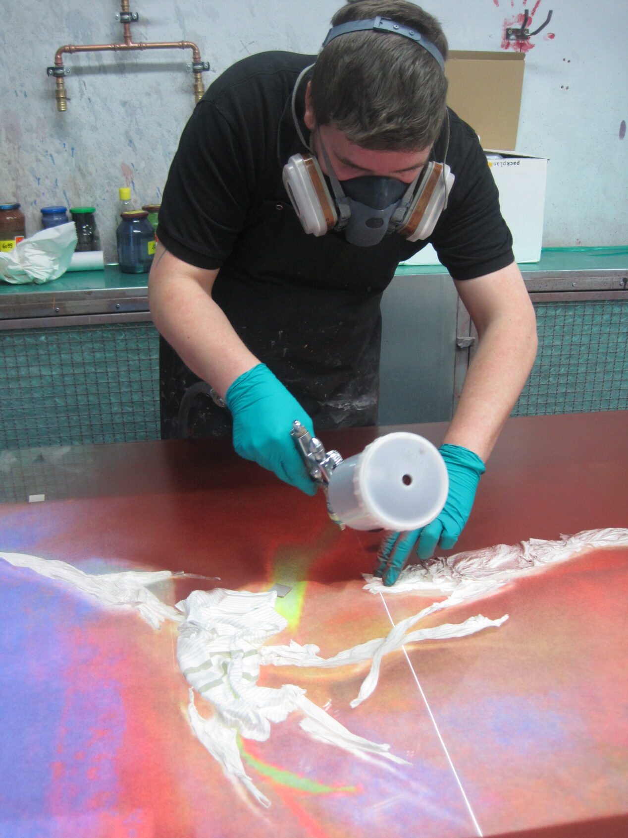 The Holy Spirit window being airbrushed with silverstain by Olaf Hanweg at Derix Glasstudios