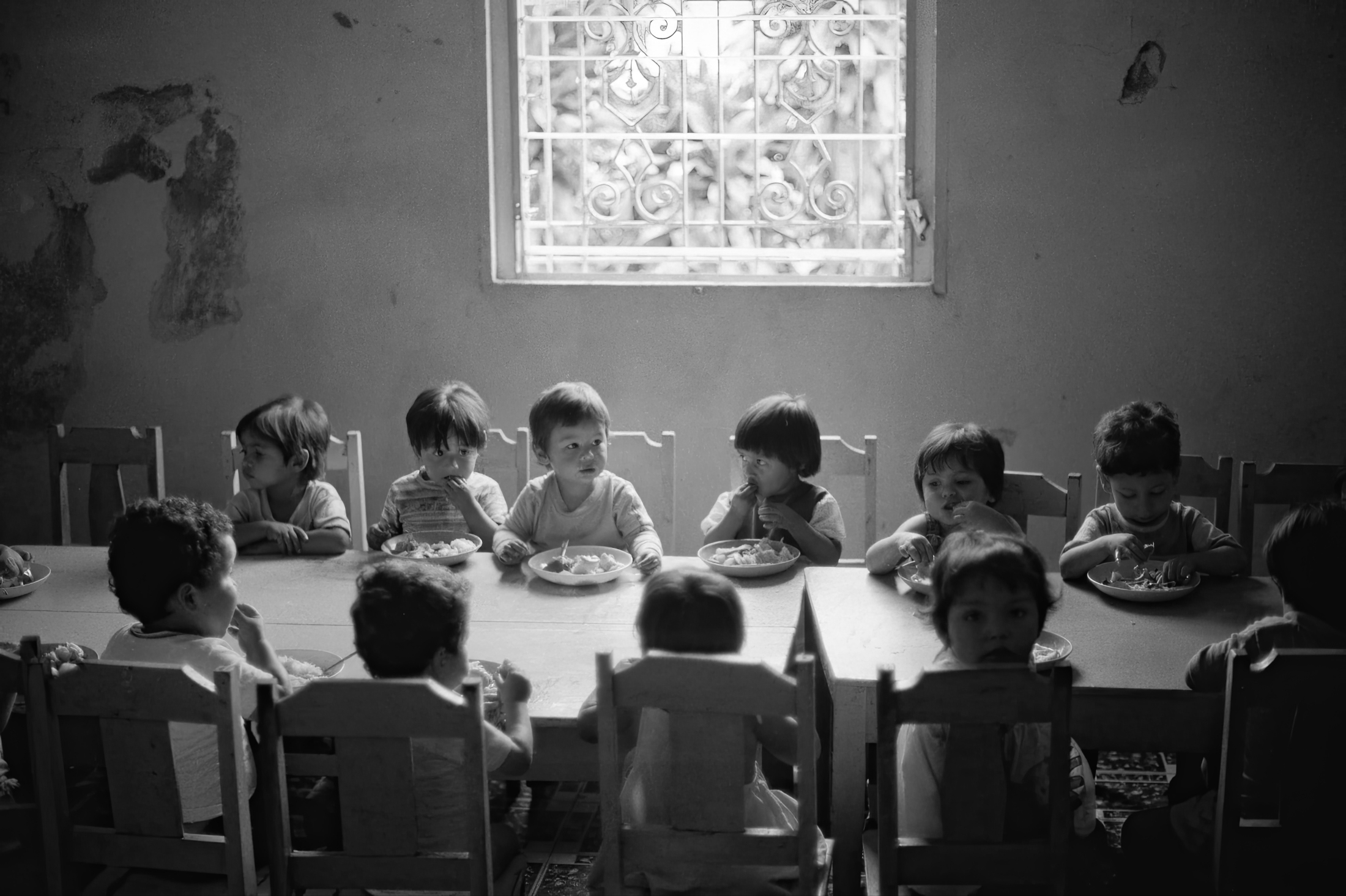Salvadoran war orphans seated at the lunch table reminiscent of the Last Supper
