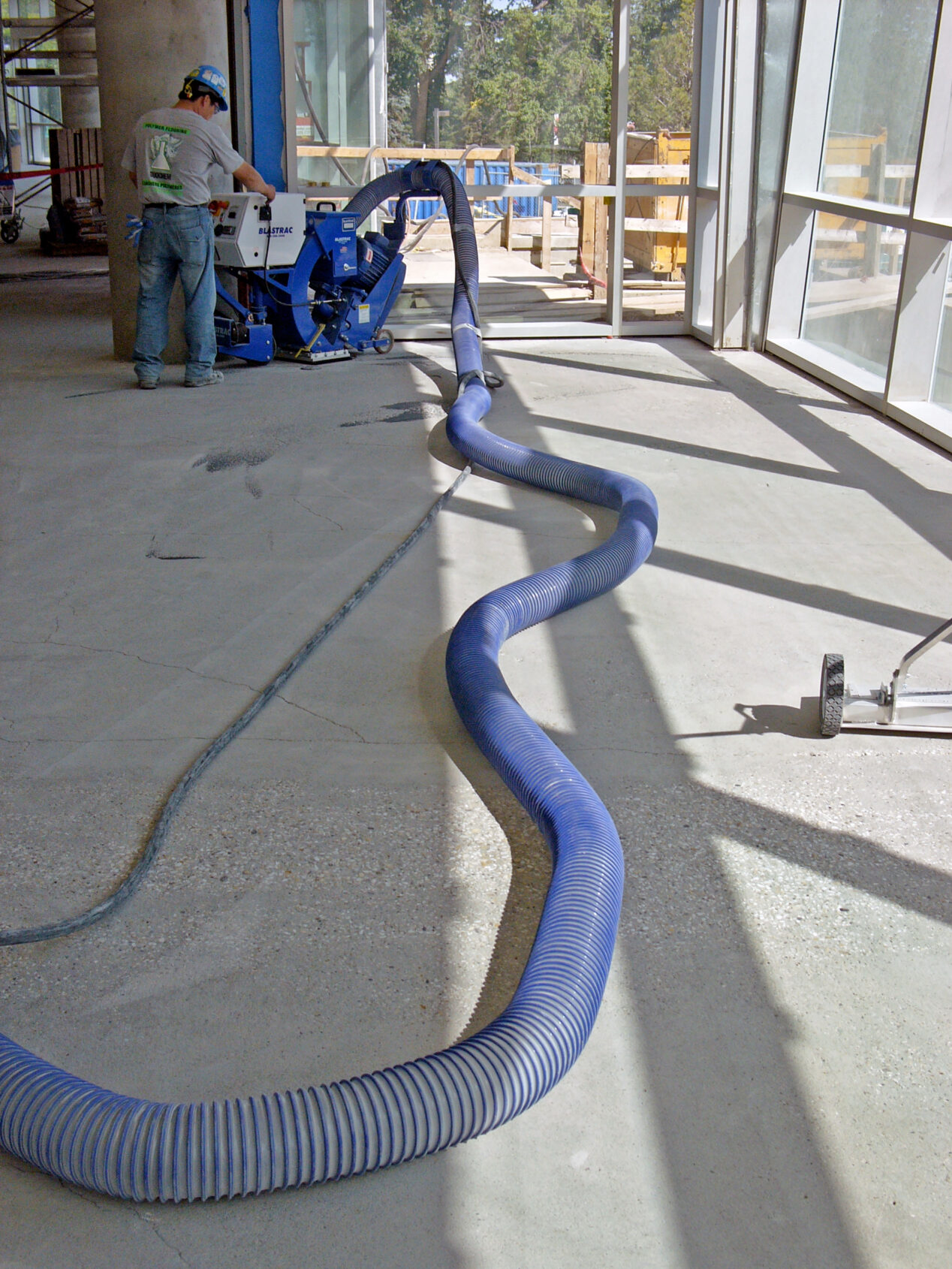 Leveling and smoothing the concrete with a blastrac machine prior to pouring the epoxy terrazzo