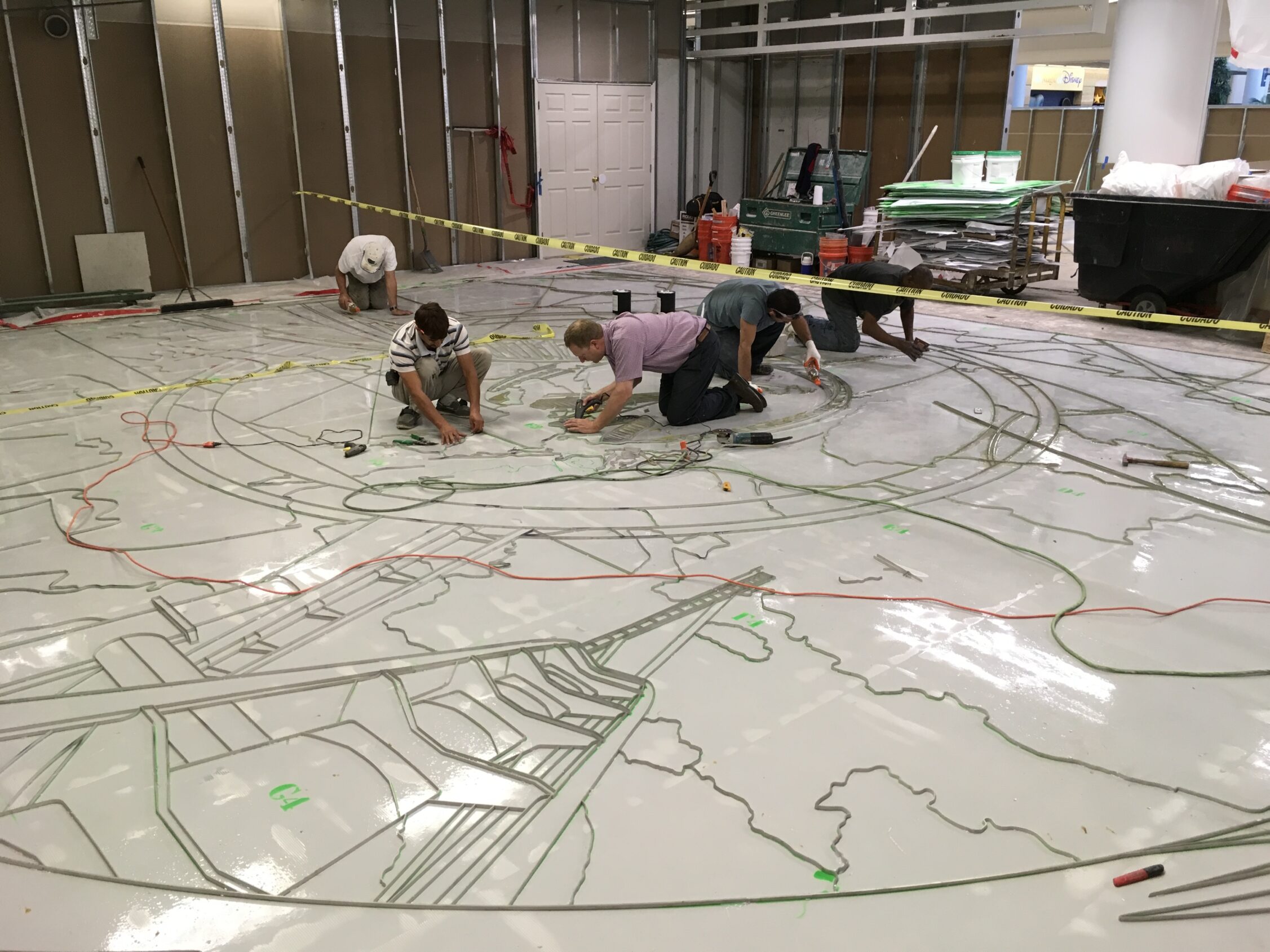 Laying divider strip for the Fun Garden artistic terrazzo floor at the Orlando International Airport