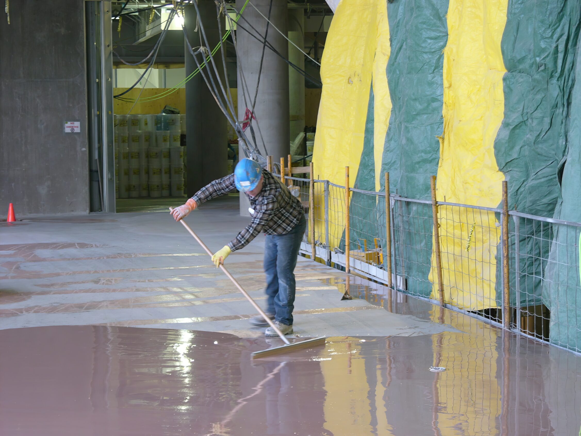 Applying the isolation membrane prior to installing the divider strip and pouring epoxy for an artistic terrazzo floor